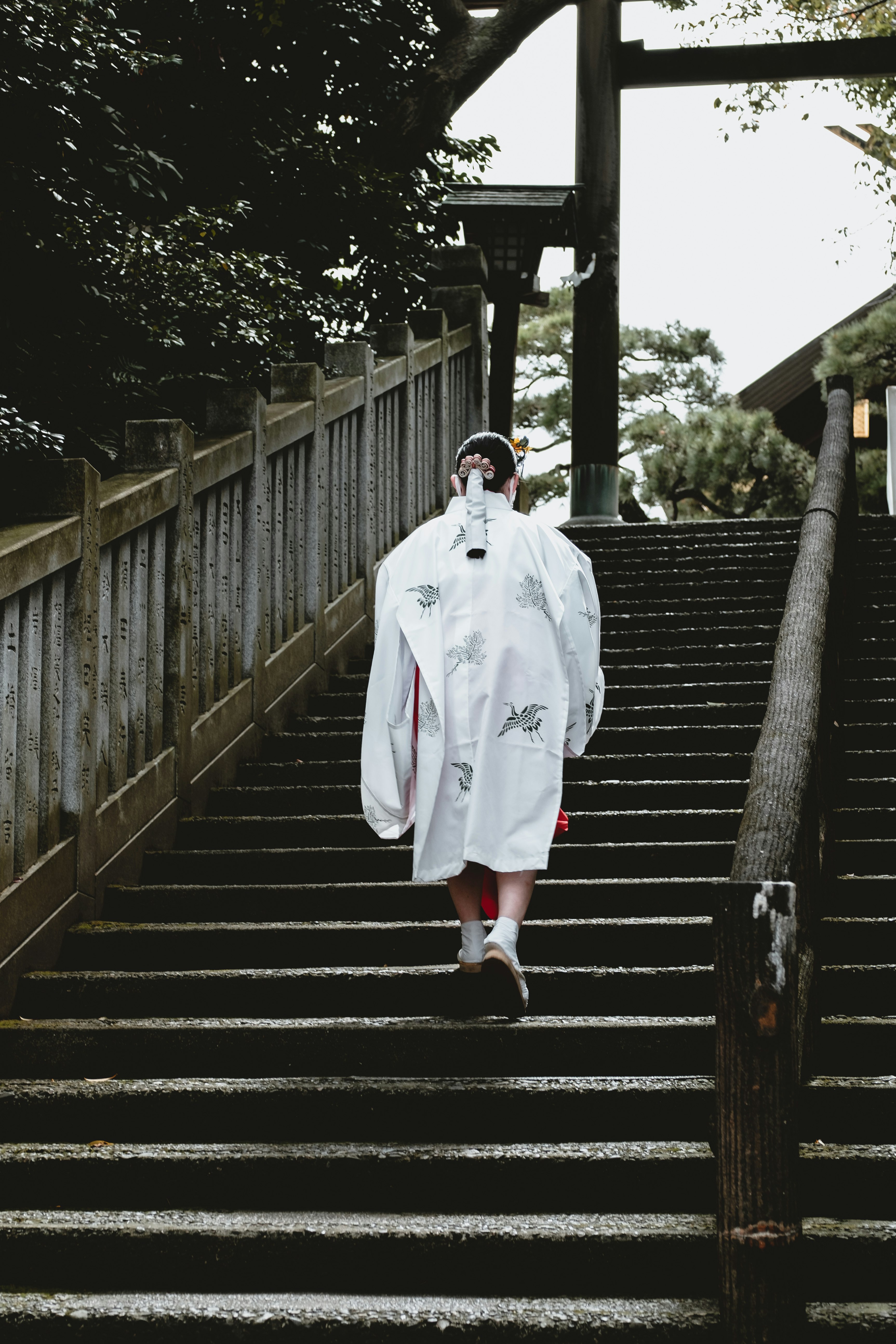 man in white robe walking on black staircase